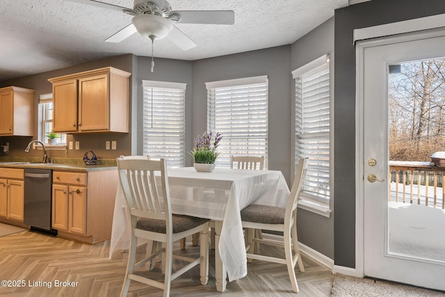 dining space featuring a textured ceiling, light parquet floors, ceiling fan, and sink