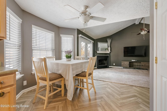 dining room featuring vaulted ceiling with beams, ceiling fan, light parquet floors, and a textured ceiling