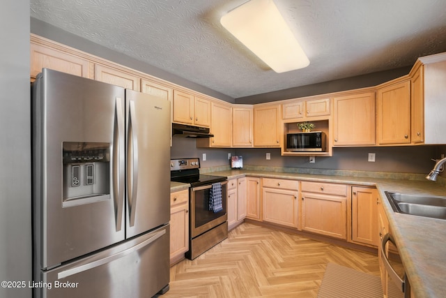 kitchen featuring light brown cabinets, sink, a textured ceiling, appliances with stainless steel finishes, and light parquet flooring