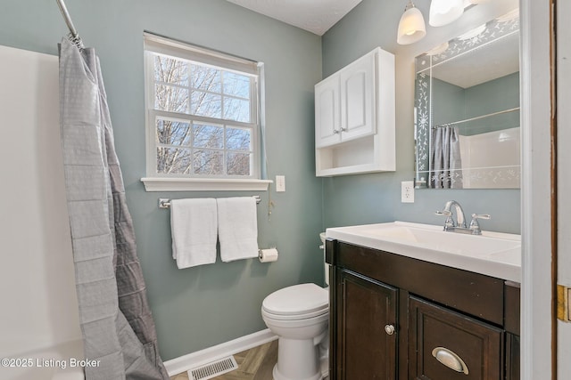 bathroom featuring parquet flooring, vanity, toilet, and curtained shower