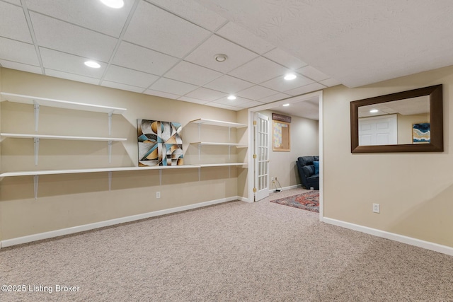 basement with a drop ceiling and carpet