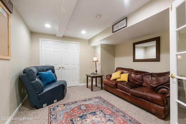 carpeted living room with beamed ceiling and a textured ceiling