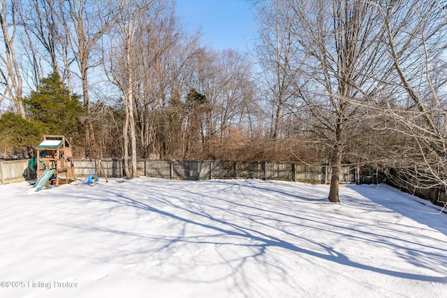 yard layered in snow with a playground