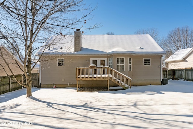 snow covered property featuring a wooden deck and central AC