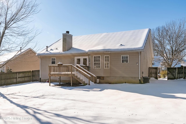 snow covered back of property featuring central air condition unit and a deck