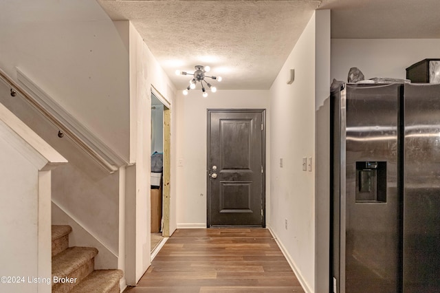 interior space featuring a chandelier, wood-type flooring, and a textured ceiling