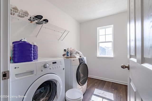 clothes washing area with a textured ceiling, washing machine and dryer, and dark hardwood / wood-style floors