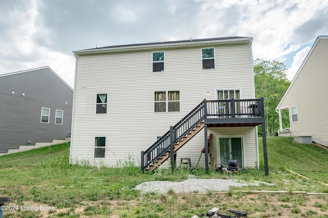 back of property featuring a yard and a wooden deck