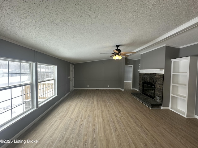 unfurnished living room with ceiling fan, wood-type flooring, vaulted ceiling, a textured ceiling, and a fireplace