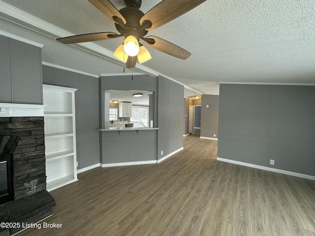 unfurnished living room featuring a textured ceiling, wood finished floors, a fireplace, and ornamental molding