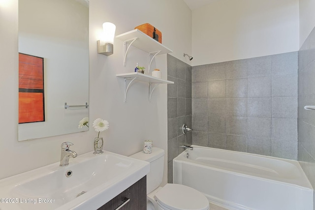 full bathroom featuring toilet, tiled shower / bath, and vanity