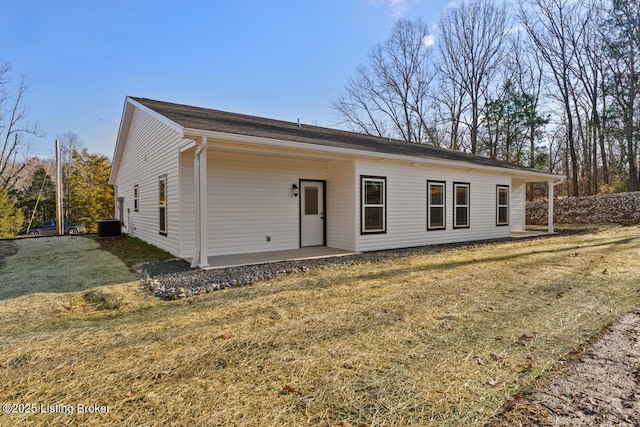 view of front of home featuring a front yard and central AC