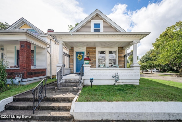 view of front of home with a porch and a front lawn