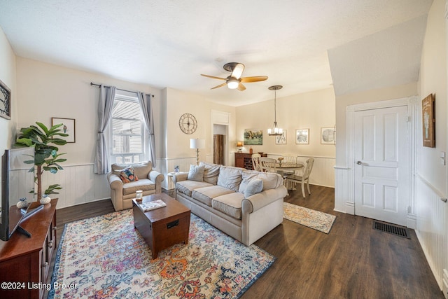 living room featuring a textured ceiling, ceiling fan with notable chandelier, and dark hardwood / wood-style floors