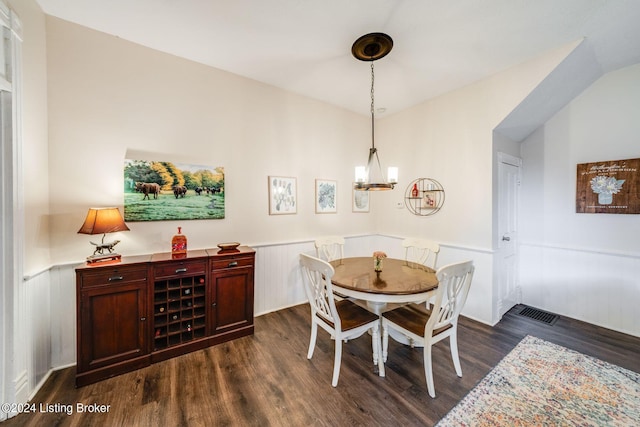 dining space featuring dark hardwood / wood-style floors and a chandelier