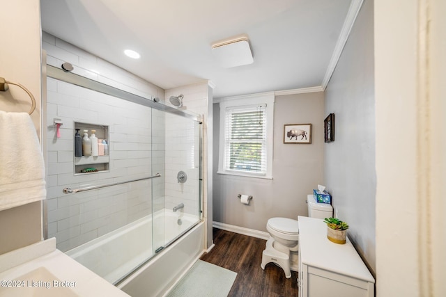 full bathroom featuring ornamental molding, vanity, shower / bath combination with glass door, hardwood / wood-style floors, and toilet