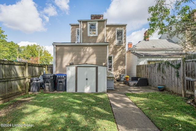 back of house featuring a lawn and a storage shed