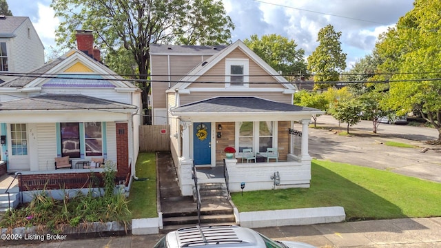 bungalow-style home featuring covered porch and a front yard