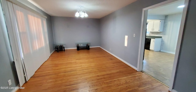 unfurnished room with light hardwood / wood-style flooring and a chandelier