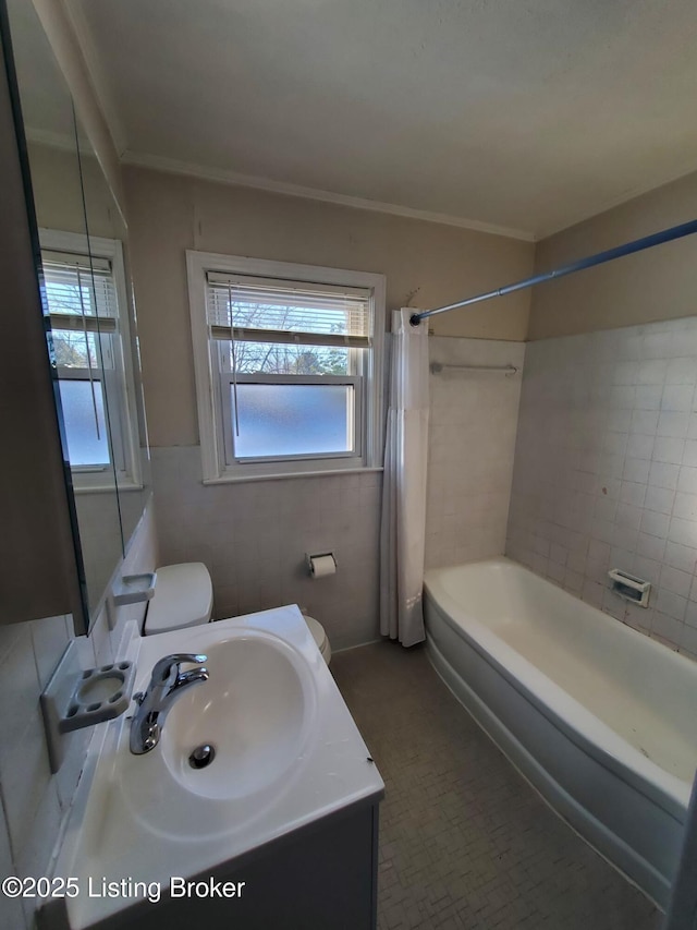 full bathroom with tile walls, shower / bath combination with curtain, vanity, and toilet