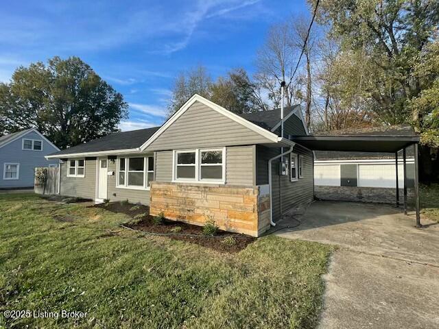 view of front of property with a front yard and a carport