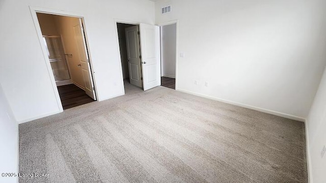 unfurnished bedroom featuring carpet flooring and ensuite bath