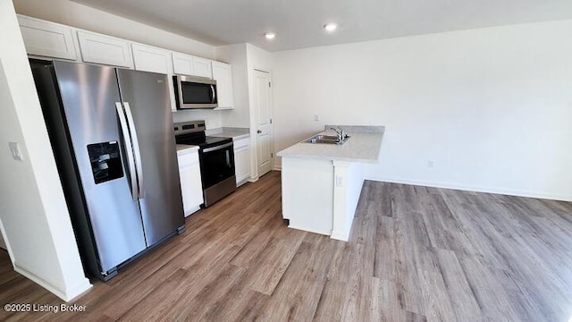 kitchen featuring white cabinets, stainless steel appliances, light hardwood / wood-style floors, and sink