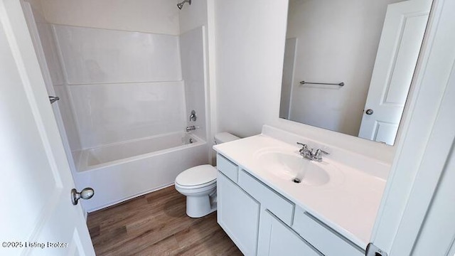 full bathroom with shower / washtub combination, vanity, wood-type flooring, and toilet