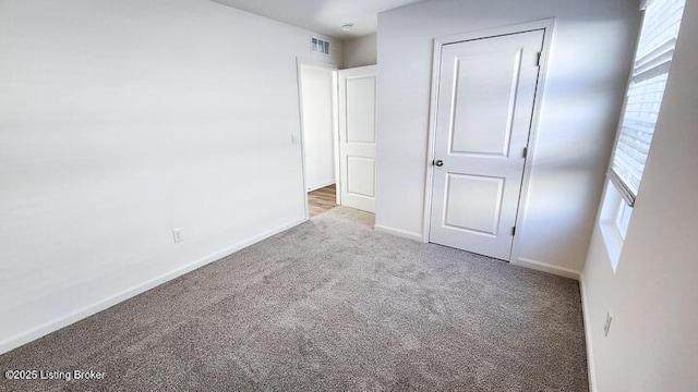 unfurnished bedroom with a closet, light colored carpet, and multiple windows