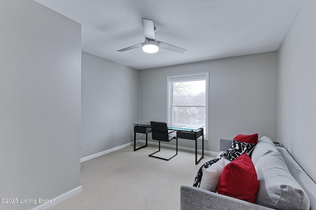 home office featuring ceiling fan, light colored carpet, and a textured ceiling