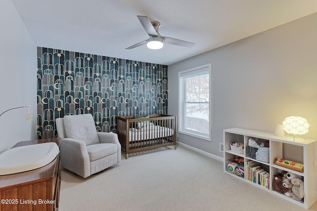 bedroom featuring ceiling fan, carpet floors, and a crib