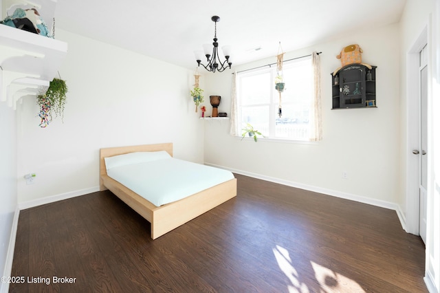 unfurnished bedroom with a notable chandelier and dark wood-type flooring