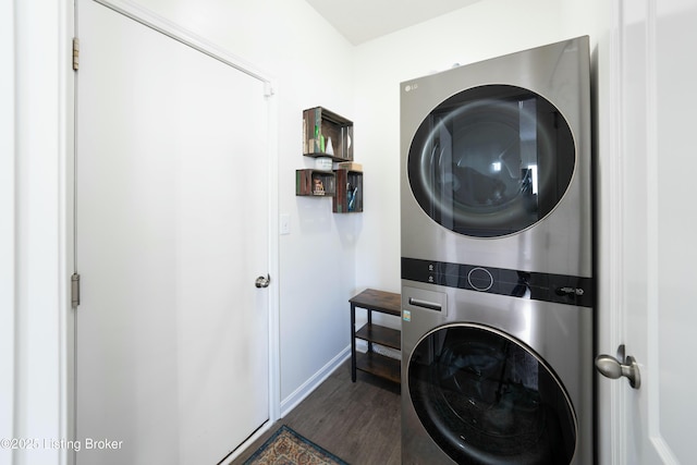 clothes washing area featuring stacked washer / drying machine and dark hardwood / wood-style floors