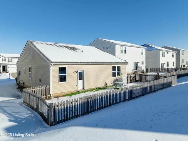 view of snow covered rear of property