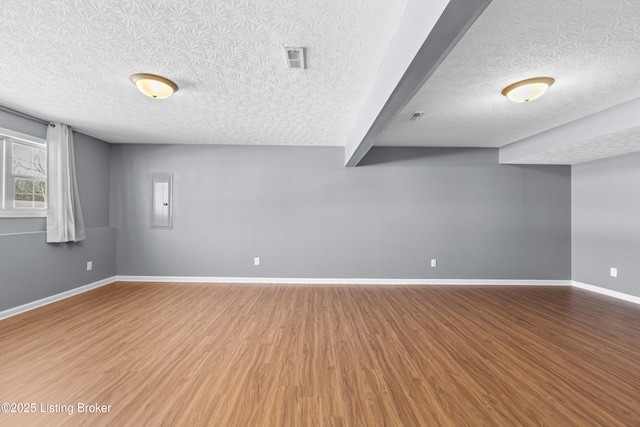 basement featuring a textured ceiling and hardwood / wood-style flooring