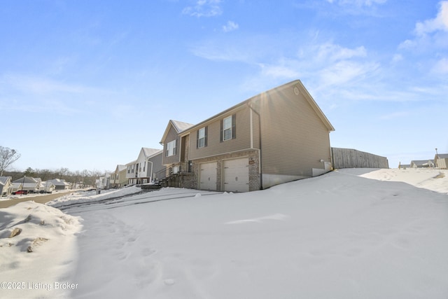 view of snowy exterior featuring a garage