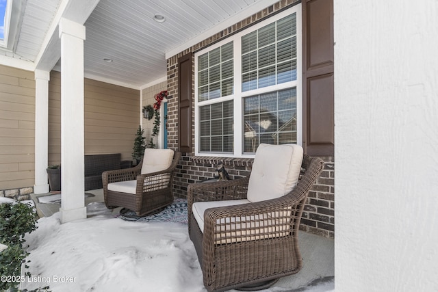 snow covered patio with a porch