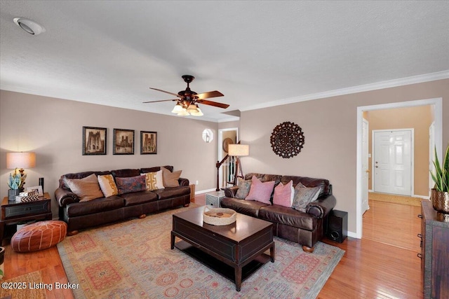 living room with crown molding, light hardwood / wood-style floors, and ceiling fan