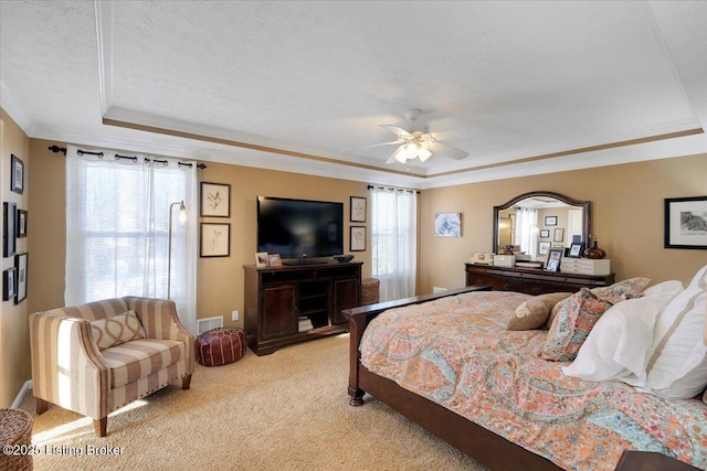 carpeted bedroom featuring multiple windows, crown molding, a raised ceiling, and a textured ceiling