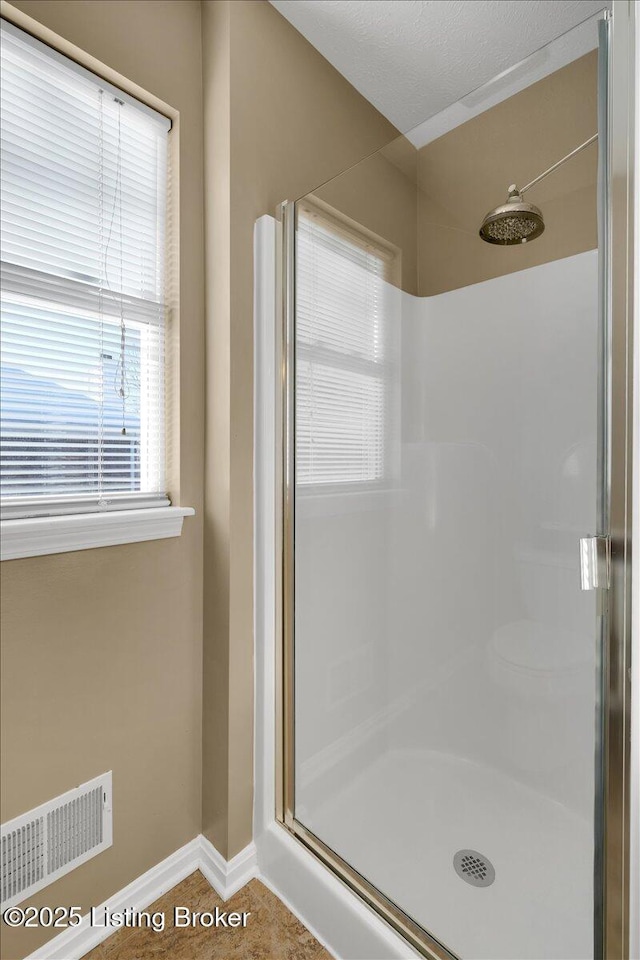 bathroom with tile patterned flooring and walk in shower