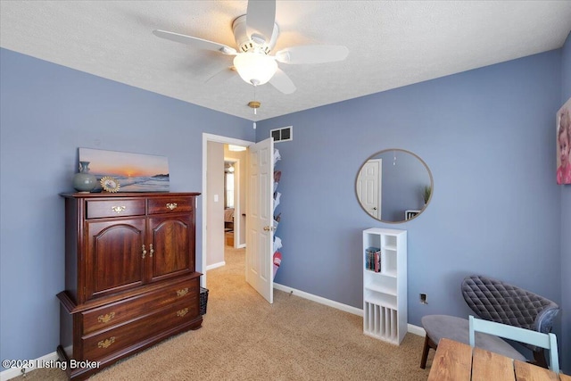 carpeted bedroom featuring ceiling fan and a textured ceiling