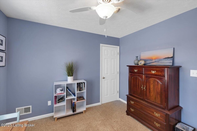 miscellaneous room with ceiling fan, light colored carpet, and a textured ceiling