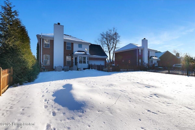 snow covered house with a garage