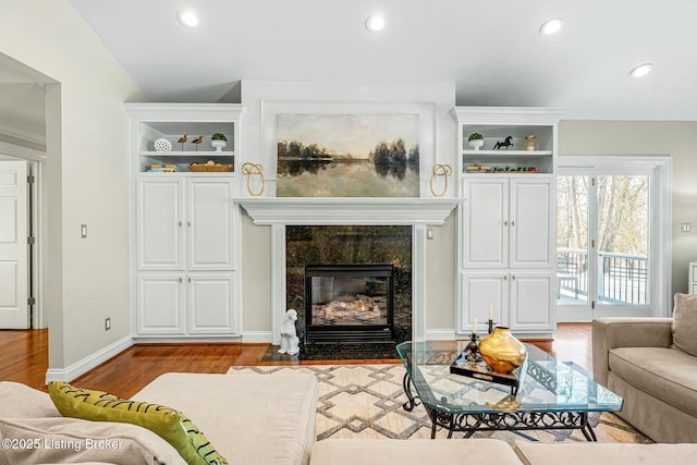 living room featuring a tile fireplace and light wood-type flooring