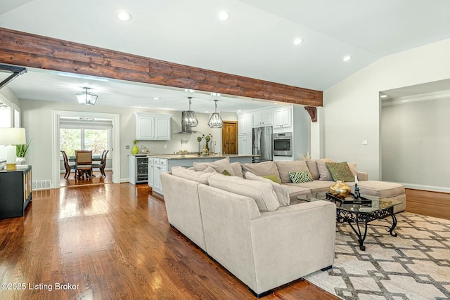 living room featuring hardwood / wood-style floors, vaulted ceiling with beams, and wine cooler