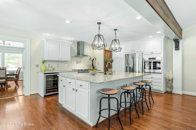 kitchen featuring white cabinetry, wall chimney range hood, and stainless steel appliances