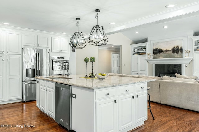 kitchen with white cabinets, a kitchen island with sink, and appliances with stainless steel finishes