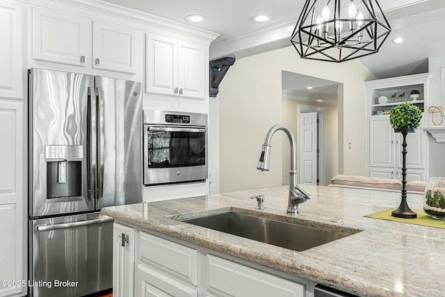 kitchen featuring white cabinets, decorative light fixtures, sink, stainless steel appliances, and light stone counters