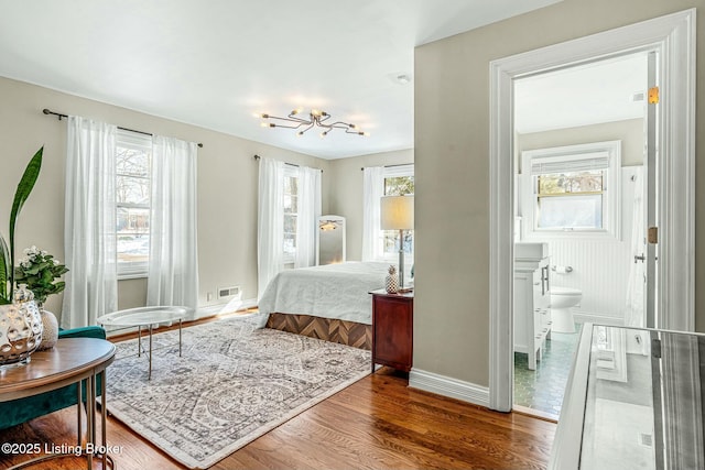 bedroom featuring hardwood / wood-style flooring and ensuite bathroom