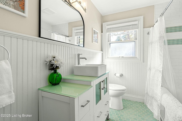 bathroom with sink, toilet, curtained shower, and tile patterned flooring